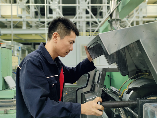 圖為成型車間機修工對ZL26C濾棒成型機組刀盤及喇叭嘴進行檢查