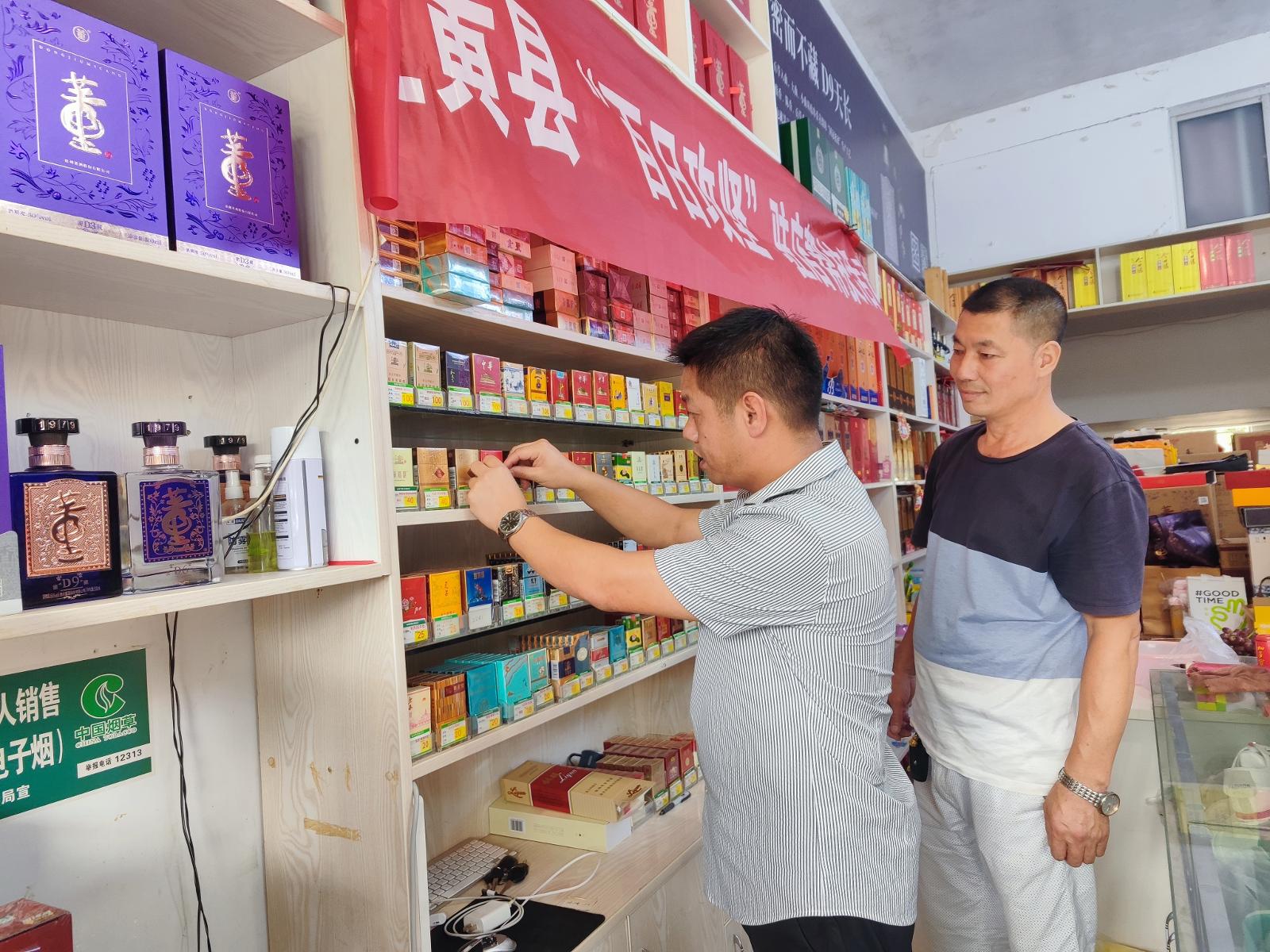圖為營銷人員協助客戶優化卷煙陳列出樣.jpg