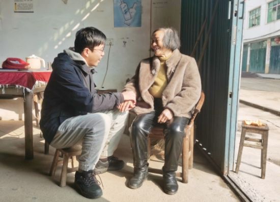 圖為進(jìn)賢煙草員工為老年零售客戶黃榮嬌溫馨交流  吳華云攝