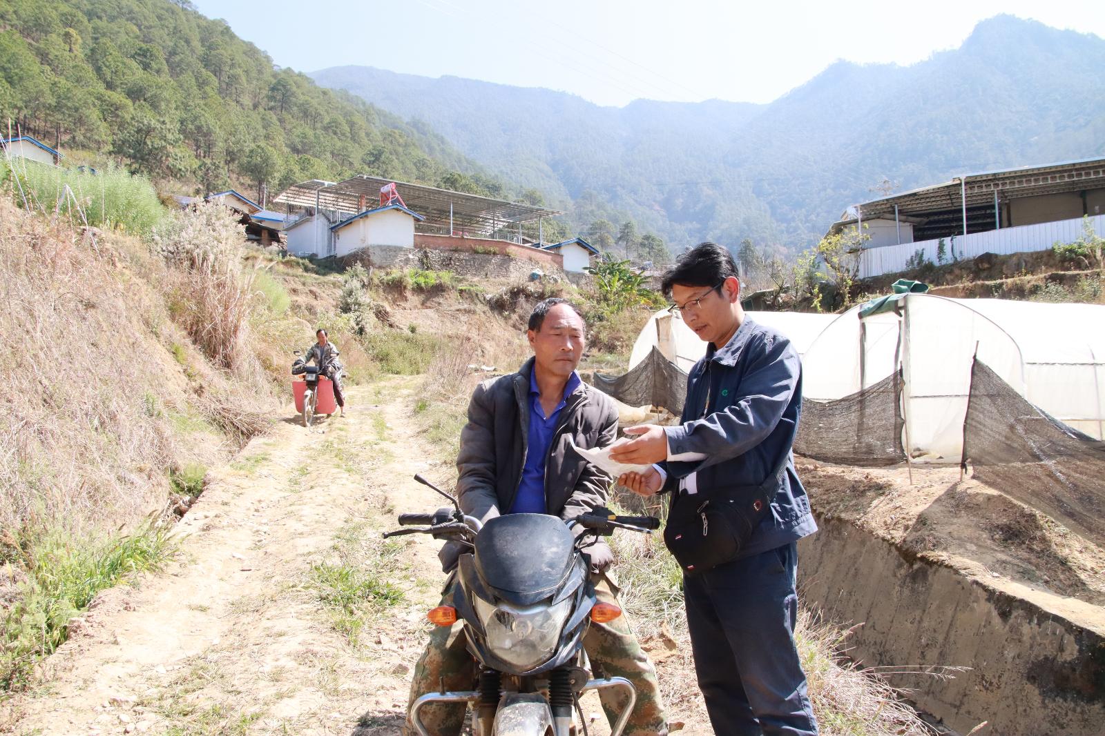 秦睿向路過的村民宣傳種煙政策.JPG