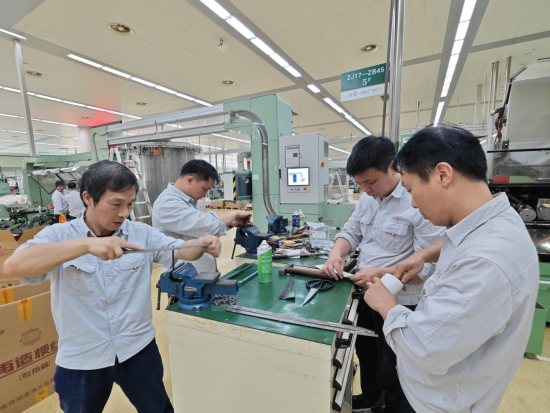 圖為該廠卷包車間維修工對(duì)卷煙機(jī)易損件進(jìn)行調(diào)整
