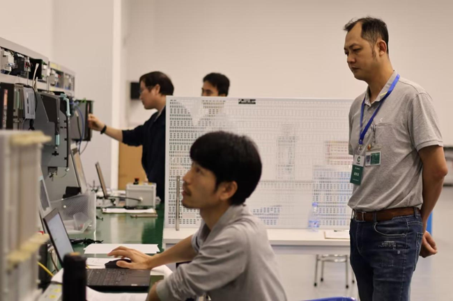職工在勞模創(chuàng)新工作室電氣技術實訓區(qū)開展項目競賽