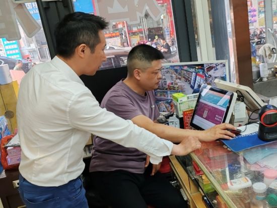 圖為客戶經理借助云POS幫助客戶分析熱銷商品數據(彭浩)
