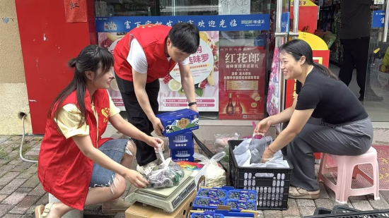 圖為志愿者正在幫助店主任吉萍打包貨品