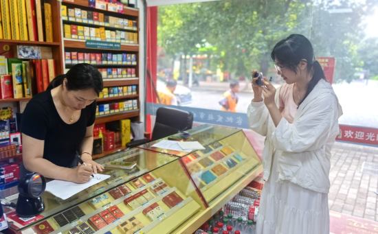 圖為志愿者正在幫助店主拍攝短視頻