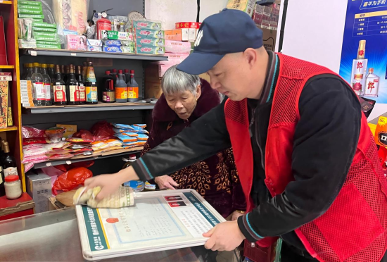圖為瑞金煙草工作人員為拔英鄉(xiāng)的年老零售戶送證上門
