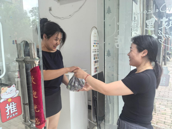 圖為店主任吉萍為顧客送貨上門