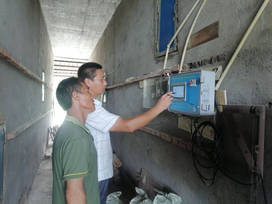 圖為煙技員唐傳東指導煙農觸摸屏自控儀操作方法
