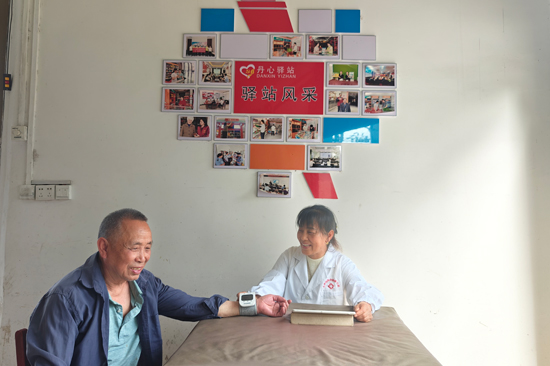 具有村醫(yī)身份的農(nóng)網(wǎng)終端店主粟林弟在為村民測量血壓 唐俊攝