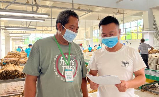 圖為煙葉收購人員向煙農(nóng)宣傳防詐騙知識