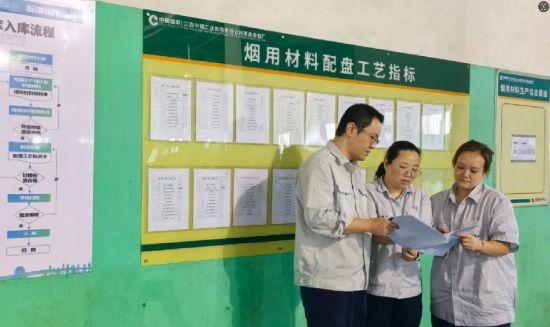 圖為煙用材料班組改善小組成員在搭配區現場開展可行性勘察討論.jpg