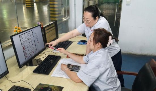 圖為煙用材料班組改善小組成員對路線規劃圖進行確認.jpg